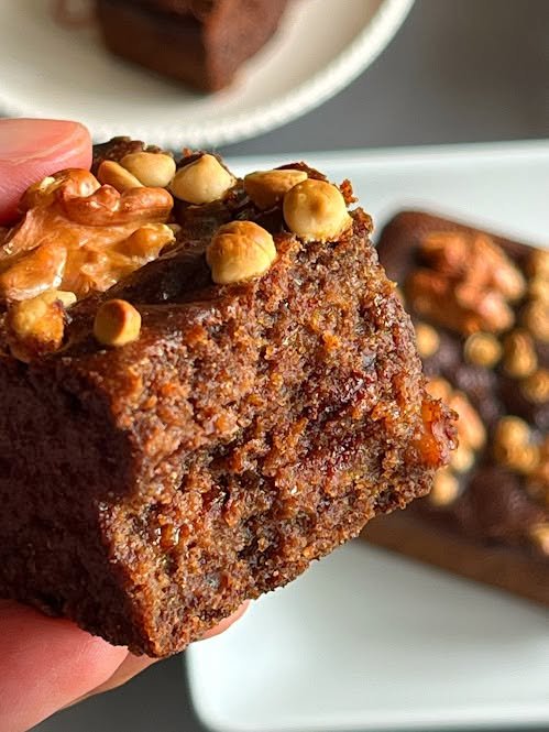 Close-up of a fudgy chocolate brownie with walnuts and a moist crumb