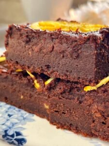 A close-up view of two decadent brownies placed on a white plate, showcasing their rich texture and chocolatey goodness.